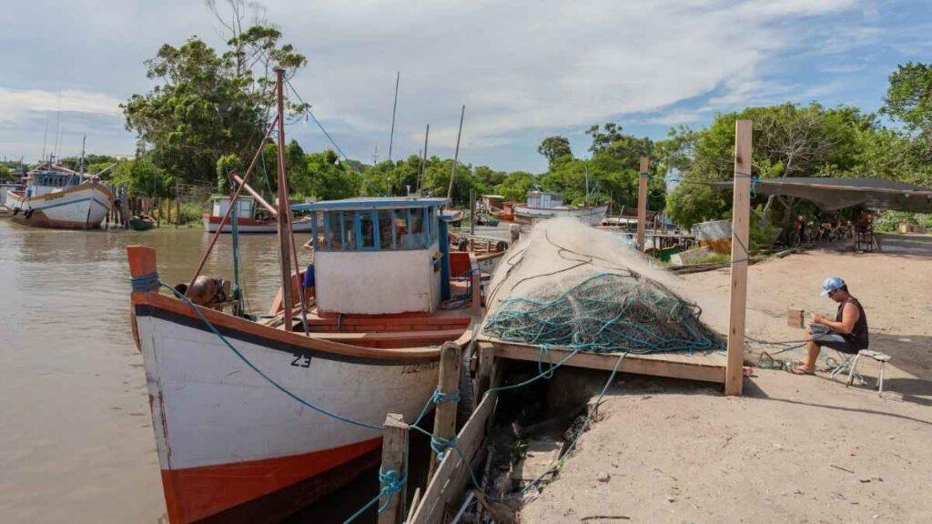 Cenário de estagnação na Colônia Z-3: barcos parados e redes vazias refletem a dificuldade de retomada da pesca artesanal em Pelotas após os recentes eventos climáticos.